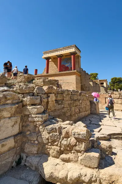 Girit. Yunanistan - 05 Mayıs 2025: Turistler, Knossos Sarayı 'nın korunmuş fresklerinden antik estetiği yansıtan koyu kırmızı ve siyah sütunlarına kadar sanatsal ayrıntılarına hayrandır..