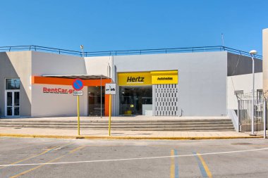Girit. Yunanistan - 05 Mayıs 2025: Hertz ve RentCar.gr adlı iki kiralık araba bürosunun girişini gösteriyor. İşletmelere giden adımlarda park yasağı uyarısı var