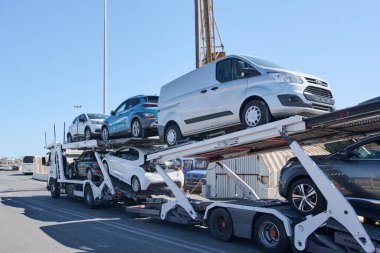 Crete. Yunanistan - 05 Mayıs 2025: SAVALIS markalı çok katlı bir taşıma kamyonu iki sıra halinde güvenli bir şekilde yerleştirilmiş, lojistik ve otomotiv ulaşımında verimliliği gösteriyor.