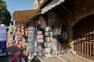 Rodas.Yunanistan - 22 Mayıs 2025: Rodos 'un göbeğinde, turistleri keşfetmeye davet eden canlı bir dizi yerel el sanatları, tekstil ve geleneksel hediyelerle süslenmiş hareketli bir hediyelik eşya dükkanı.