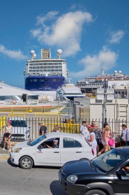 Rodas.Yunanistan - Haziran 05, 2025: Rodos 'un yoğun limanındaki bir yolcu gemisinden araçlar ve liman altyapısıyla inen insanlar, gelen turistlerin akışını kaydediyor