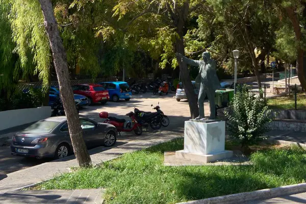 Rodas.Yunanistan - Haziran 06, 2025: Yunanistan 'ın Rodos kentindeki halka açık bir parktaki Eleftherios Venizelos heykeli, ağaçlar, park edilmiş araçlar ve çimlerle çevrili, tarihi bir noktayı yakalıyor.