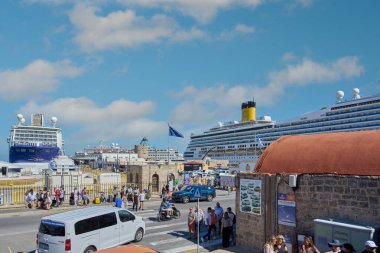 Rodas.Yunanistan - Haziran 05, 2025: Rodos limanında yoğun bir gün, turistler ve yerliler hareketli liman boyunca ilerlerken, yolcu gemilerinin ufuk çizgisine hakim olduğu bir gün. Ziyaretçilerin dinamizmi.