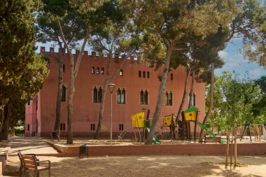 Viladecanlar. Barcelona - 16 Temmuz 2025: Canlı bir açık hava oyun alanının gündüz sahnesi, modern ekipmanların antik Viladecan mimarisi ile güzel bir tezat oluşturduğu yer.