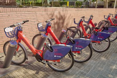 Viladecanlar. Barcelona - 16 Temmuz 2025: İstasyonda park halindeki Ambici ortak bisiklet kuyruğu, çevre dostu kentsel hareketliliği ve aktif taşımacılığı destekliyor.