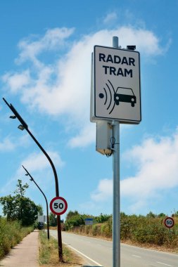 Viladecanlar. Barselona - 14 Ağustos 2025: Şehir-kırsal bir çevrede tramvay radarlı bir karakol. Hız limiti işaretleri mevcut, sürücüler için bir uyarı mesajı oluşturuyor.