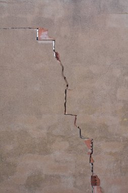 Çürüme ve kırılganlığını gösteren büyük bir çatlakla dolu bir duvarın grunge dokusunun ayrıntıları. İnşaat ve bakım sorunları için ideal bir görsel kavramdır..