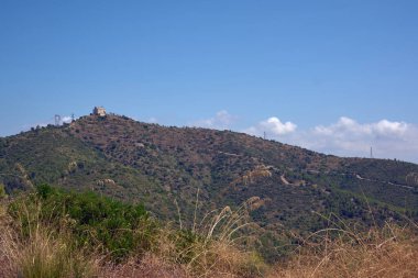Sant Ramon 'un Hermitage' ı dağın tepesinde, aşağıdaki manzaranın güzel bir manzarasını sunuyor. Kiliseye giden yol yerden görülebiliyor..
