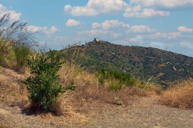 Ermita de Sant Ramon, bir dağ manzarasının merkezi noktasıdır. Güneşli hava ve açık gökyüzü bu tarihi yerin güzelliğini vurguluyor..