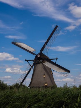 Hollanda 'daki Kinderdijk yel değirmeni. Tipik Hollanda yel değirmeni. UNESCO Dünya Mirası Alanı. Beyaz bulutlu mavi gökyüzü