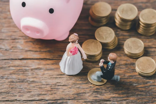 Düğün ve düğün planlama için para biriktir. Aile hayatı ya da evlilik hayatı için sürdürülebilir finansal amaç. Yükselen madeni paralar üzerinde minyatür düğün, yeni aile için tasarruf veya büyümeyi resmediyor.