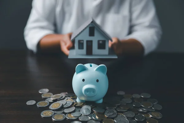 Saving investment home with loan finance money business concept. Investment banking finance for residential real estate business. Stack coins with model house for investment loans.Cash for taxes.