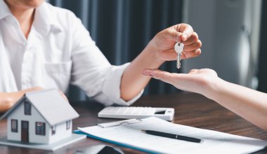 Business person hands holding home model, small building red house. Real estate agents offer contracts to purchase or rent residential. Mortgage property insurance moving home and real estate concept