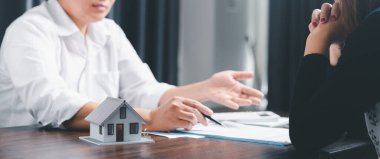 Real estate agents offer contracts to purchase or rent residential. Business person hands holding home model, small building red house. Mortgage property insurance moving home and real estate concept
