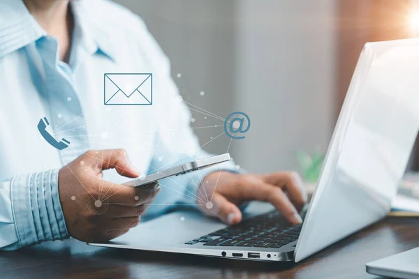 Telefon kullanan ve elektronik posta, adres, canlı sohbet, internet kablosuz internet gibi sanal ekran iletişim simgelerine dokunan bir iş kadını. Bizimle ya da müşteri destek hattıyla iletişime geçin. Siber uzaya bağlan.