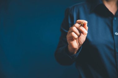 Closeup of businesswoman hand on empty dark blue background in office for design work, insert icon bundle or business technology symbols or other. selective focus on hand. female online working