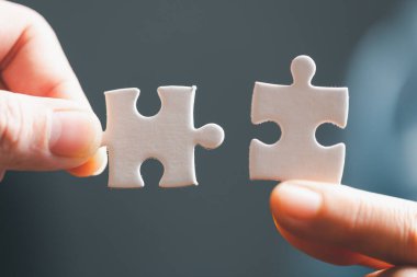 Business woman person hand holding puzzle piece idea for strategy and solution. Closeup part of two white jigsaw connect together. Concept of join cooperation success teamwork-problem corporate team