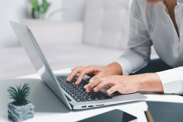 Sosyal medya günü konsepti. Kadın serbest çalışan, günün erken saatlerinde modern dizüstü bilgisayar kullanarak oturma odasında web sitesi için kahve içmeye başlıyor. İç işlerinde çalışan iş kadını..