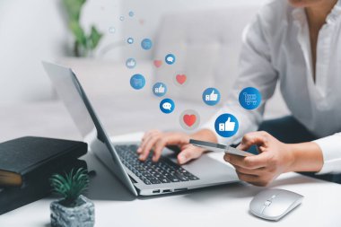 Sosyal ağ servisi ya da sosyal medya konsepti olan akıllı telefon kullanan bir iş kadını. Dizüstü bilgisayar kullanan ve online pazarlama işi için evde kalan bir kadın. Sosyal medya işi.