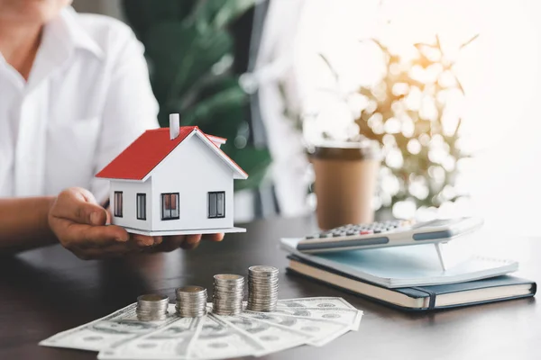 Saving investment home with loan finance money business concept. Investment banking finance for residential real estate business. Stack coins with model house for investment loans. Cash for taxes.