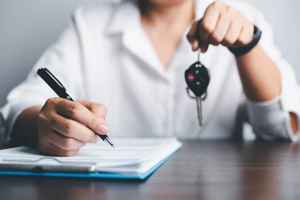 Car key for Vehicle Sales Agreement. New carowners are taking keys from male salespeople. Concept of car insurance business, saving buy - sale with tax and loan for new car.