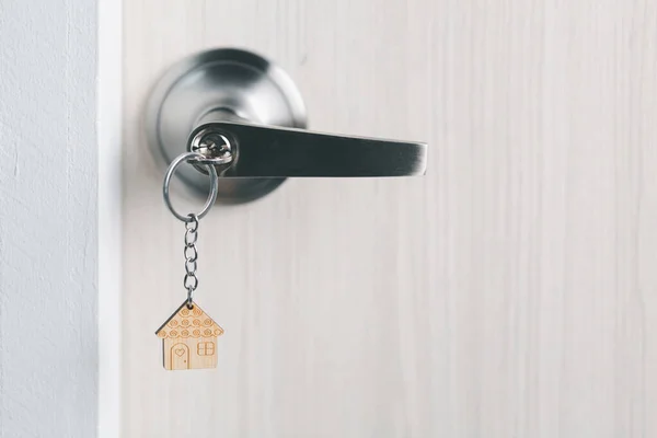 stock image close up key on the door with morning light, personal loan concept. House model and key in house door. Real estate agent offer house, property insurance and security, affordable housing concepts.