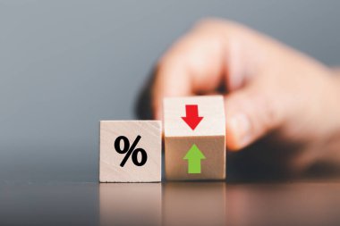 Yüzdelik sembollü yakın çekim tahta küpleri, tahta küplerde yüzde ve yukarı doğru yükselen oklar. Mali faiz ipotek oranlarında artış veya fiyat komisyonuna zam, büyüme işi, finans vergisi.