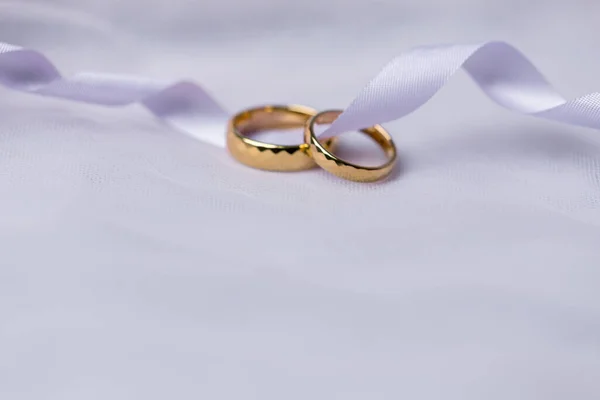 金戒指订婚 金戒指 粉色丝带背景 白玫瑰和红玫瑰上的戒指 结婚戒指是情侣们传统婚礼的象征 — 图库照片