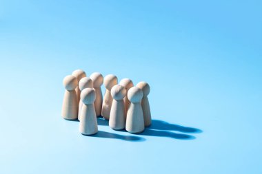 Ahşap bir takım çalışması sembolü. Liderlik stili strateji işbirliği kavramı. Şirketten bir grup çalışan. Açık mavi arkaplanı olan ahşap sembol. Profesyonel iş grubu.