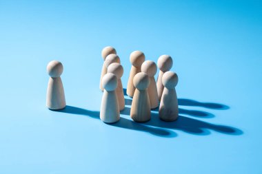 Ahşap bir takım çalışması sembolü. Liderlik stili strateji işbirliği kavramı. Şirketten bir grup çalışan. Açık mavi arkaplanı olan ahşap sembol. Profesyonel iş grubu.