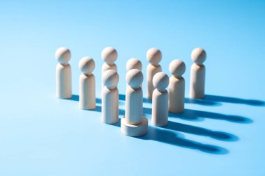 Ahşap bir takım çalışması sembolü. Liderlik stili strateji işbirliği kavramı. Şirketten bir grup çalışan. Açık mavi arkaplanı olan ahşap sembol. Profesyonel iş grubu.
