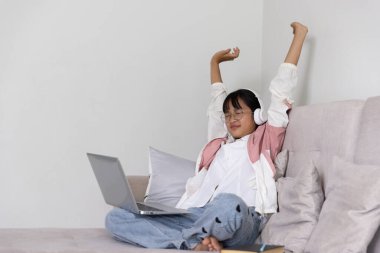 Öğrenci kız çevrimiçi çalışmaktan mutlu, okul konseptine geri dönüyor. Çalışmakla meşgul genç bir kız öğrenci not defterine not alır ve bilgisayarla çevrimiçi eğitim teknolojisi eğitimi verir..