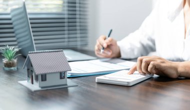 Hesap makinesi kullanarak kadın ellerini kapat ve ofis giderlerini hesaplayarak yaz..