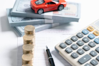 Minyatür araba modeli, hesap makinesi ve masa başındaki kalem. İş, finans, tasarruf, bankacılık veya araba kredisi konsepti. Araba, bozuk para ve kopyalama alanı olan hesap makinesi.