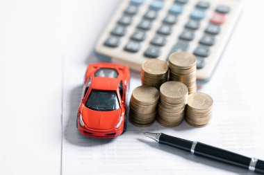 Minyatür araba modeli, hesap makinesi ve masa başındaki kalem. İş, finans, tasarruf, bankacılık veya araba kredisi konsepti. Araba, bozuk para ve kopyalama alanı olan hesap makinesi.