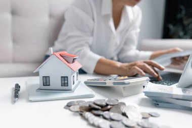 Konsantre Asyalı kadın harcamaları hesaplıyor, kağıt banka faturalarını analiz ediyor, aylık bütçeyi yönetiyor, yatırım planlıyor, bilgisayar uygulaması kullanarak hizmet veya hizmetleri ödüyor.