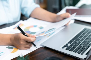 İş kadınları şirket mali istatistiklerini, beyin fırtınası fikirlerini ve masadaki grafik dokümanlarını incelemek için birlikte çalışıyorlar..