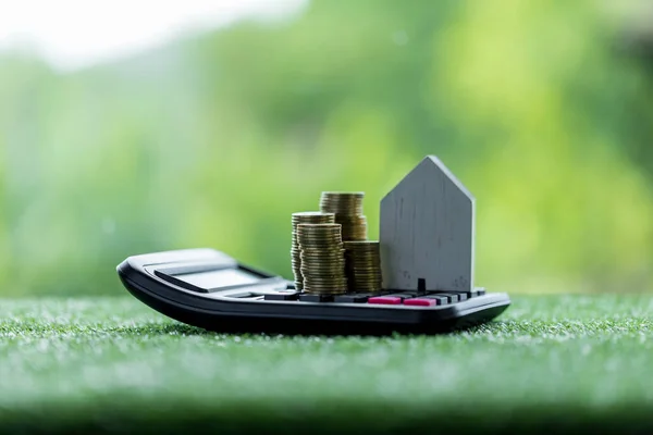 Business loans for real estate concept, money with model home on the table on bokeh background in the public park.