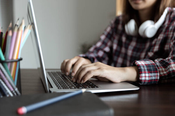 Concentrated student girl learning online having video call via laptop computer sitting at home interior near open balcony, female entrepreneur working remotely from home office using modern computer