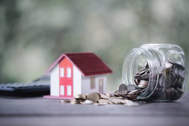 Huzurlu doğa geçmişinde ev kredisi ve madeni paralar. Finans, Yatırım ve Gayrimenkul Konsepti. Huzurlu Doğa Arkaplanı 'nın ortasındaki madeni paralar. Mali Büyüme, Gayrimenkul Yatırım ve Tasarruf.