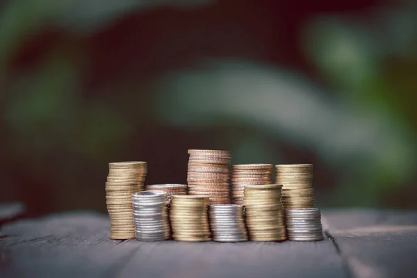 Coin pile and blurred green nature background money growth concept and business success concept. Stack of coins on blurred green natural background for business and financial growth concept.