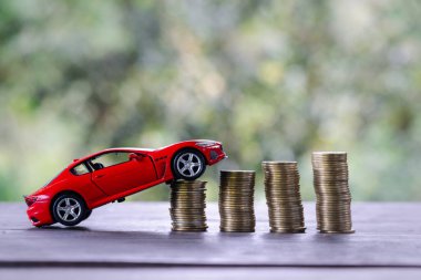 Para yığınları üzerinde araba modeli. Finans ve araba kredisi, araba için tasarruf, madeni para sigortası, kredi ve araba finansmanı kavramı. Alış ve taksitler bir araba peşinatı.