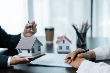 Genç bir kadın bir bankerle ev kredisi için buluşuyor, emlak konsepti. Onaylanmış mortgage başvuru formu, ipotek kredisi teklifi ve konut sigortası hakkında.