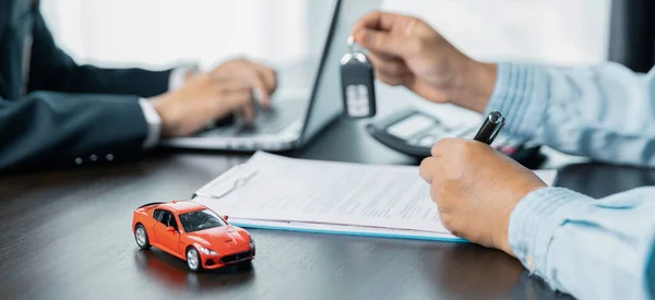 Car dealers or insurance managers cover and protect against damage and risk of driving,Hold car keys,Protecting and after-sales care concept.successful car loan contract buying or selling new vehicle.
