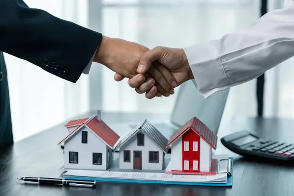 Emlakçı ve müşteriyle birlikte ev modeli satın almak, sigorta yaptırmak ya da emlak ya da mülk almak için görüşüyorlar. Onaylanmış mortgage başvuru formu, ipotek kredisi teklifiyle ilgili.