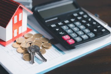 Mankenli paralar ahşap masada, tasarruf para konsepti, emlak yatırımı, ev kredisi, ters ipotek, altın para yığını büyümesi, para biriktirme yığını ev için gelecek yığını