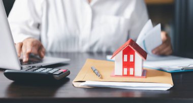 Emlakçı ve müşteriyle ev modeli ev, sigorta ya da kredi emlak geçmişi için sözleşme hakkında tartışıyorlar. Para biriktirmek ev için gelecek istiflemek