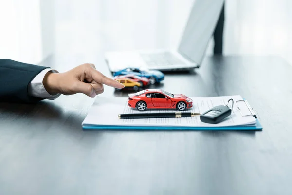 Business concept, car insurance, sell and buy car, car financing, car key for vehicle sales agreement. A car dealer is explaining to customers about loans with rental car insurance. Buying a car.