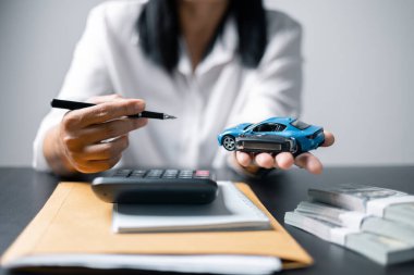Araba sigortası işi, tasarruf satışı, yeni araba için vergi ve kredi. Arka planda bozuk para yığını olan oyuncak araba. Ulaşım finansmanını yönetmeyi planlıyorum. Araba için kredi