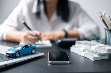 Araba sigortası işi, tasarruf satışı, yeni araba için vergi ve kredi. Arka planda bozuk para yığını olan oyuncak araba. Ulaşım finansmanını yönetmeyi planlıyorum. Araba için kredi